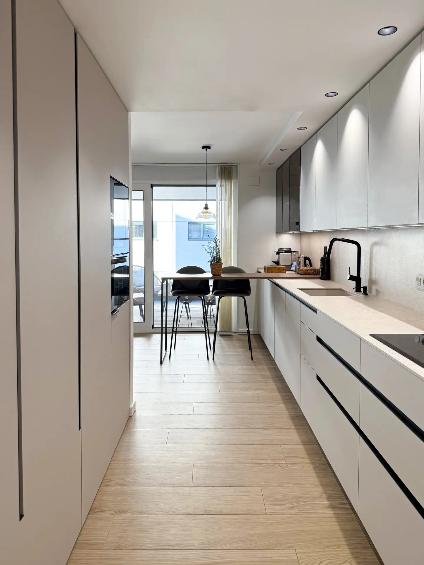 Diseño de cocina sin isla con acabados en visón y nogal natural