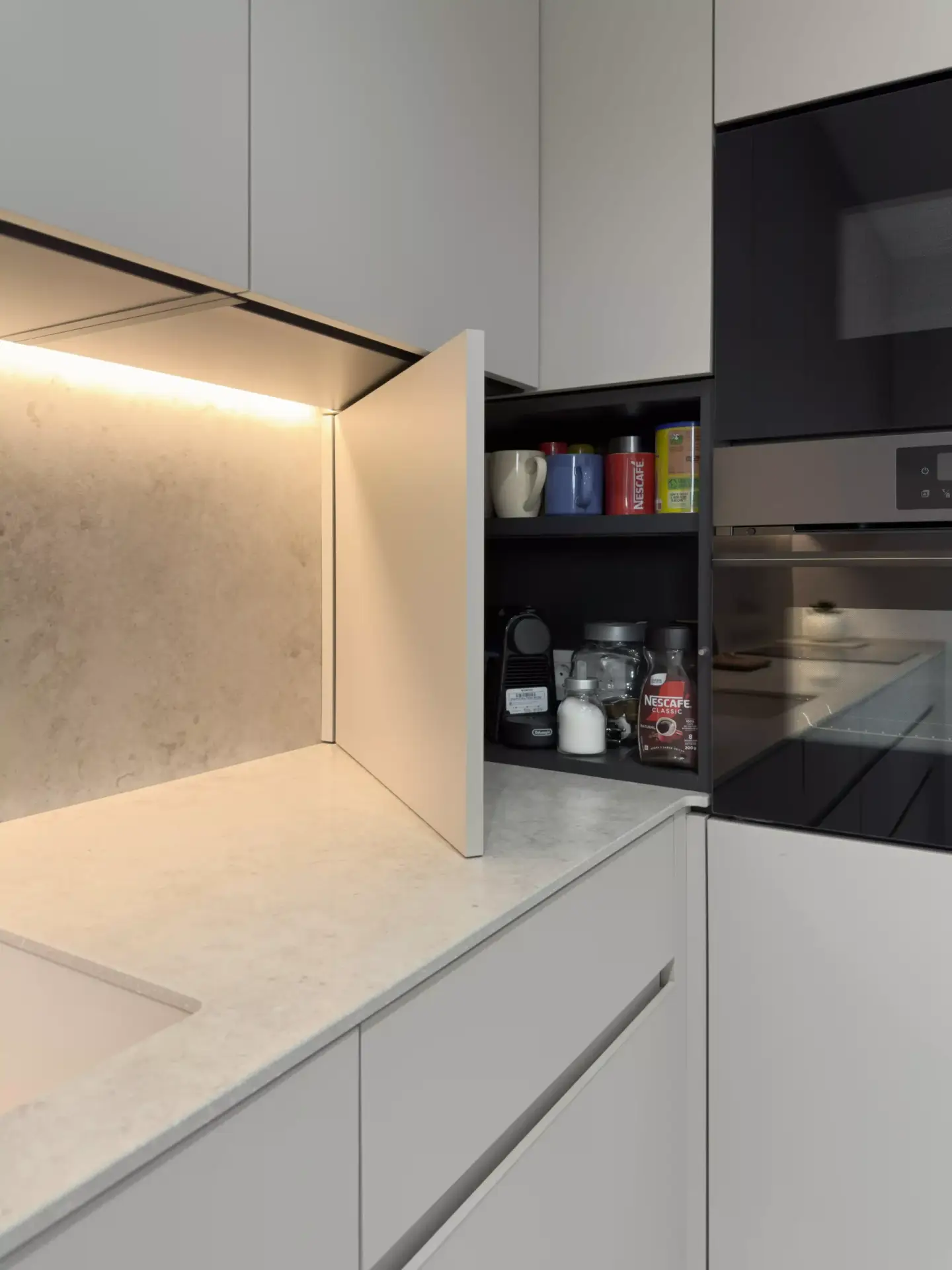 Solución de almacenamiento bajo encimera en cocina con diseño Gola Pura y acabados en Laminado Arena