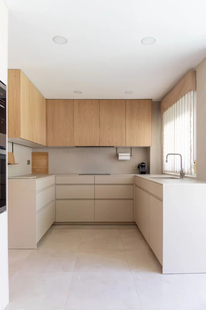 Vista general de cocina en U con muebles en acabado arena y muebles altos en roble Casella.